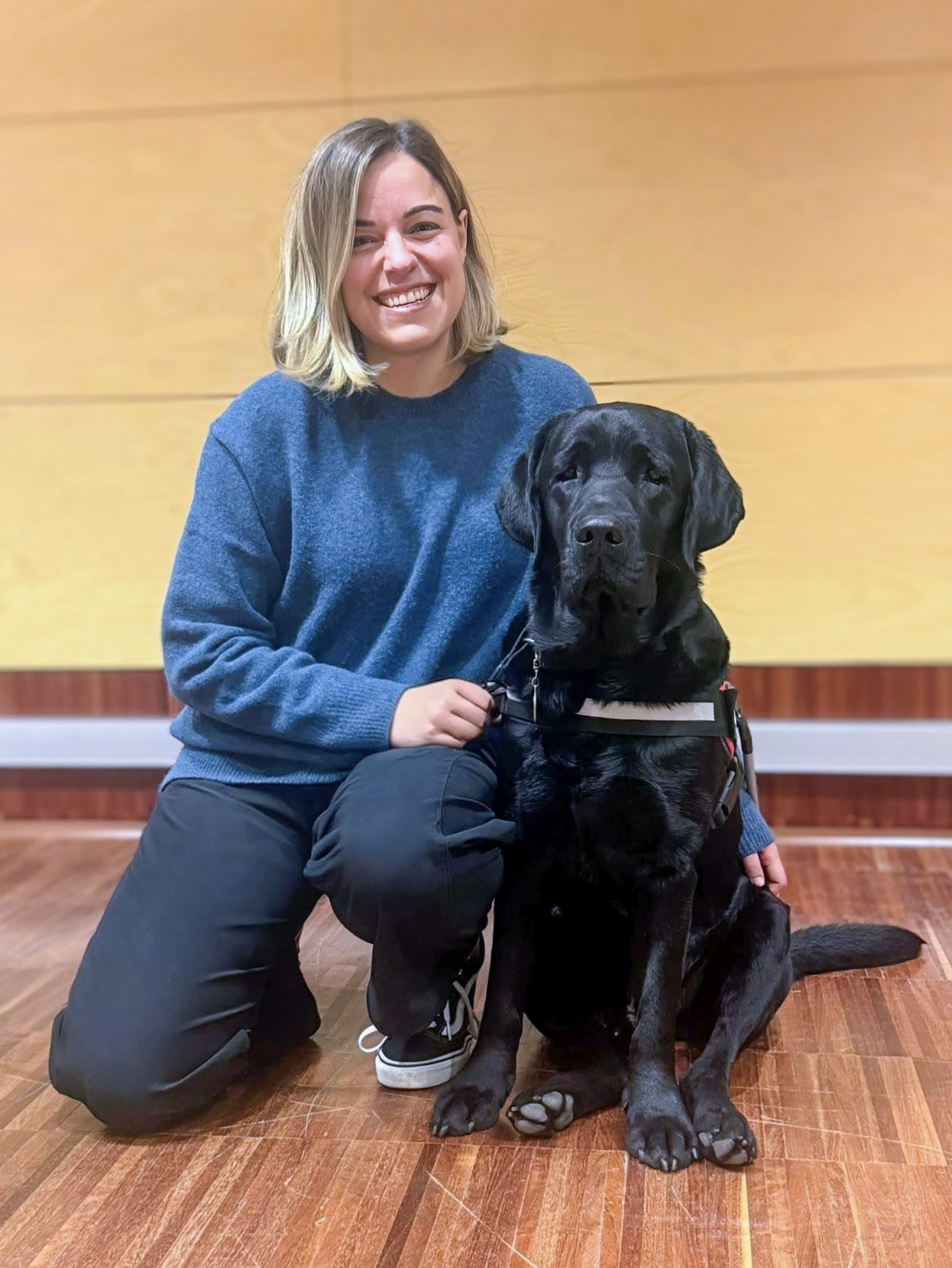 Alba kneeling next to a black labrador